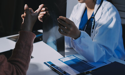 The doctor explain the old lady in retired life patient on lungs x-ray film and discuss treatment...