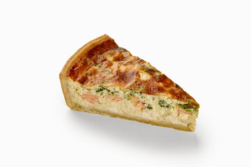 Slice of quiche with salmon and spinach filling on white background