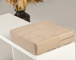 Beige fabric cushion resting on modern white bench