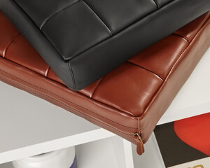 Two leather cushions resting on white shelf, showcasing modern interior design