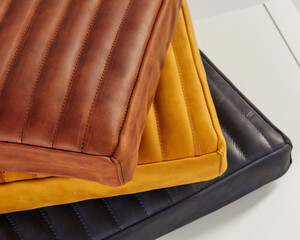 Stack of colorful leather cushions exhibiting exquisite craftsmanship