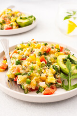This healthy salad combines boiled millet, chickpeas, fresh vegetables, and avocado, all drizzled with olive oil for a nutritious and flavorful vegetarian meal