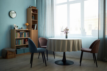 Dining table with chairs in the middle of dining room with big window