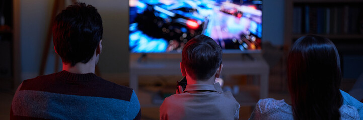Header with family playing video game together at home
