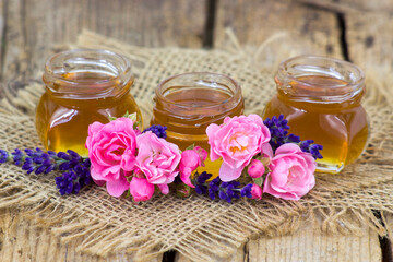 honey and flowers on wooden background