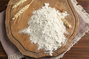 Pile of flour and spikes on wooden table, top view