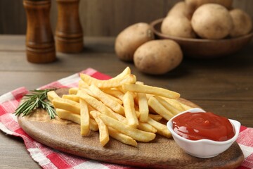 Tasty french fries with ketchup and rosemary on wooden table, closeup