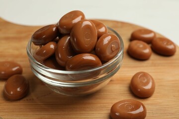 Many tasty caramel candies on white table, closeup