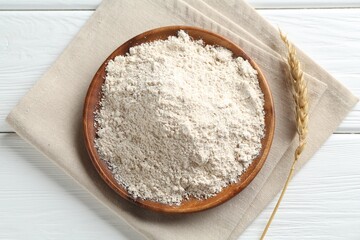Flour and spike on white wooden table, flat lay