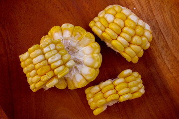 Fresh Corn on the Cob Sliced and placed on a wooden cutting board, ready for cooking.