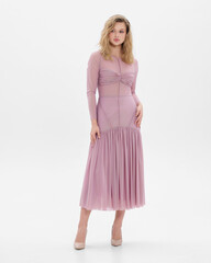 Girl model in pink dress on white studio background.