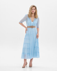 Girl model in blue dress on white studio background.