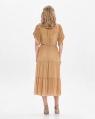 Girl model in beige dress on white studio background.