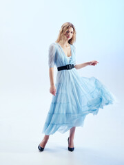 Naklejka premium Girl model in blue dress on blue studio background.