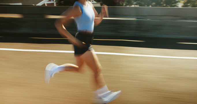 Motion blur, fitness and body of woman running on bridge in city for race, marathon or training. Sports, speed and female athlete on highway with cardio workout, challenge or exercise in town.
