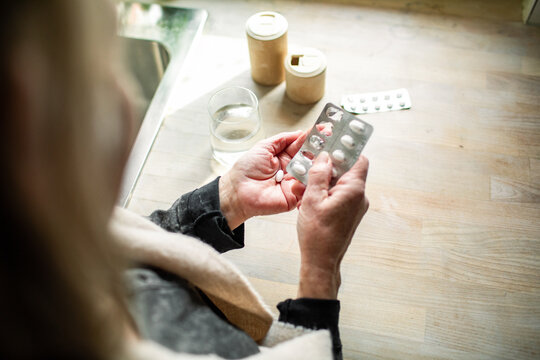 Senior caucasian woman taking pills and perscription drugs at home