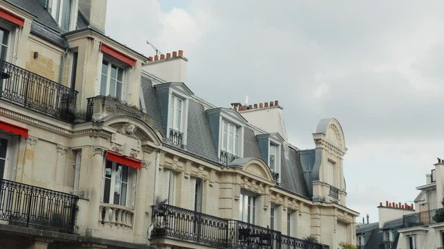 Parisian building facade with red awnings and grey roof