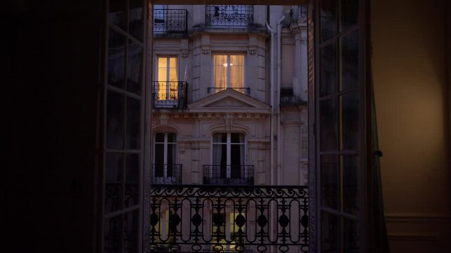 Warm lights shining through parisian apartment windows at dusk