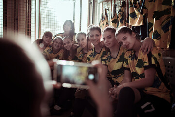 Girls soccer team getting ready in locker room before game