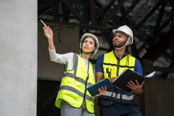 man civil engineer and woman architect wearing blue safety helmet meeting at contruction site....