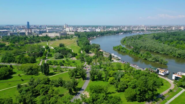 Aerial view of Belgrade where the Sava and Danube rivers meet. Visible landmarks include Kalemegdan Fortress (Beogradska tvrđava), city bridges, and U&scaron;će Park &mdash; a perfect urban-meets-nature panorama