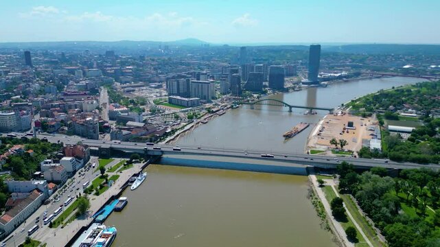 Aerial view of Belgrade where the Sava and Danube rivers meet. Visible landmarks include Kalemegdan Fortress (Beogradska tvrđava), city bridges, and U&scaron;će Park &mdash; a perfect urban-meets-nature panorama