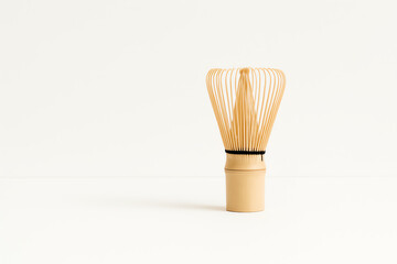 A beautifully crafted bamboo whisk, traditionally used in Japanese tea ceremonies, showcases its elegant design against a minimalist background, emphasizing simplicity and craftsma