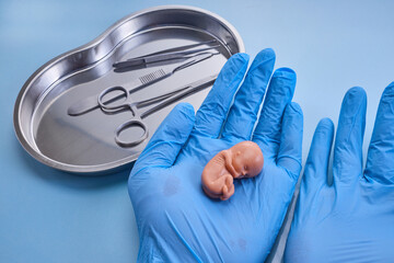 Symbol of child abortion and termination of pregnancy. Medical Tools and Model.