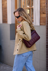 Girl model on the street in stylish clothes with a bag. Street style fashion.