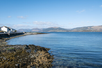 stunning rugged rocky Scottish coastline landscape from Bute island looking into the clear cold blue water Firth of Clyde on a gorgeous sunny day.
