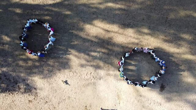  Group of countrywomen and gauchos in traditional dress dancing Argentine folklore