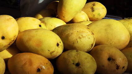 Ripe mangoes stacked in a fruit stall
