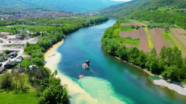 Aerial view of Bajina Ba&scaron;ta and the iconic Kućica na Drini (Drina River House), peacefully perched on a rock in the middle of the emerald Drina River, surrounded by lush nature and mountain landscapes