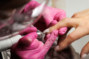 Electric File Manicure for French Nail Style, Close-up of a nail technician using an electric nail drill to shape and clean nails.