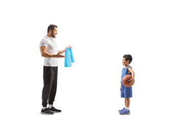 Full length profile shot of sports coach talking to a boy with a basketball