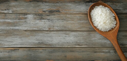 Wooden spoon full of uncooked rice on rustic wooden table
