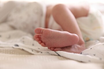 Little baby lying on bed indoors, closeup