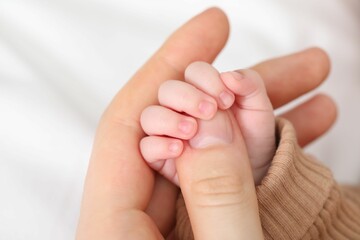 Mother with her little baby on bed indoors, closeup