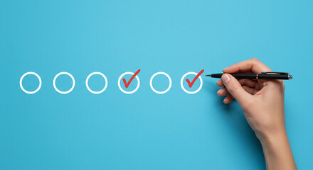 Hand marking checklist with pen on blue background showing completed tasks and remaining items to mark real estate business ,technology ,selling ,purchasing ,agreement