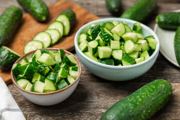 Cucumber on wooden background. Slice of cucumber on background. Fresh organic green cucumbers gherkin. Vegan. Salad ingredient. Farm vegetables. Cut vegetables with knife. Space for text. Copy space
