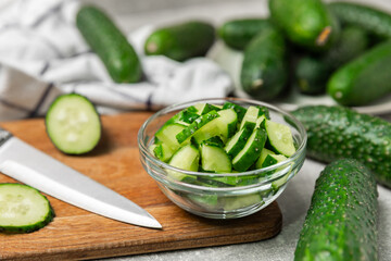 Cucumber on wooden background. Slice of cucumber on background. Fresh organic green cucumbers gherkin. Vegan. Salad ingredient. Farm vegetables. Cut vegetables with knife. Space for text. Copy space