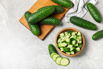 Cucumber on wooden background. Slice of cucumber on background. Fresh organic green cucumbers gherkin. Vegan. Salad ingredient. Farm vegetables. Cut vegetables with knife. Space for text. Copy space