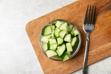 Cucumber on wooden background. Slice of cucumber on background. Fresh organic green cucumbers gherkin. Vegan. Salad ingredient. Farm vegetables. Cut vegetables with knife. Space for text. Copy space