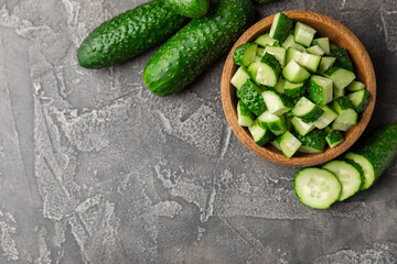 Cucumber on wooden background. Slice of cucumber on background. Fresh organic green cucumbers gherkin. Vegan. Salad ingredient. Farm vegetables. Cut vegetables with knife. Space for text. Copy space
