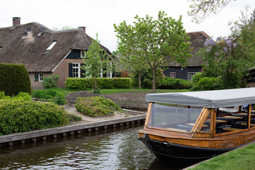 Giethoorn, Netherlands – A picturesque village with canals and rustic thatched-roof houses in a...