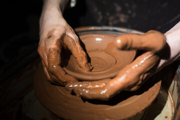 A person is making a pottery piece with their hands