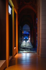 Bologna’s historic center on a rainy night, with illuminated porticoes glowing over wet cobblestones in Emilia-Romagna, Italy