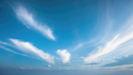 Witness the beauty of a clear blue sky gradually fading into gentle white clouds, presenting a calm and scenic landscape.