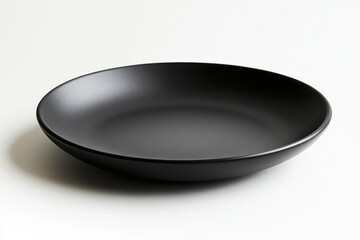 Black bowl on white surface filled with vivid red strawberries, creating a vibrant contrast.