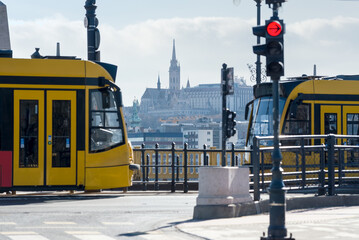 Distant view of Matthias church between two trams on Margaret bridge